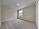 Clean bedroom featuring neutral carpet, a window, and a closet perfect for a simple and restful space at 3002 Sunscape Ter, Groveland, FL 34736