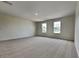 Bright, open bedroom featuring neutral carpeting and two windows, perfect for a serene retreat at 3002 Sunscape Ter, Groveland, FL 34736