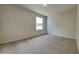 Minimalist bedroom with neutral carpeting and a window, offering a calming space at 3002 Sunscape Ter, Groveland, FL 34736