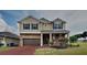 Charming two-story home featuring a stone facade, attached two-car garage, and well-manicured landscaping at 3002 Sunscape Ter, Groveland, FL 34736