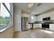 Modern kitchen with stainless steel appliances, white cabinets, and tile floors at 3002 Sunscape Ter, Groveland, FL 34736