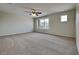 Large main bedroom featuring carpeted floors, a ceiling fan, and a large window at 3002 Sunscape Ter, Groveland, FL 34736