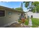 Exterior view of the home with a patio, storage area, and lush green landscaping at 781 Little Pine Dr, South Daytona, FL 32119
