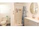 Clean bathroom with a stand-up shower featuring a curtain, toilet, and a vanity with a round mirror at 781 Little Pine Dr, South Daytona, FL 32119