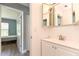 Bright bathroom featuring a modern vanity with a large mirror, white tile, and a glimpse into the adjacent bedroom at 781 Little Pine Dr, South Daytona, FL 32119