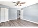 Spacious bedroom with light blue walls, wood-look flooring, a ceiling fan, and a double door closet at 781 Little Pine Dr, South Daytona, FL 32119