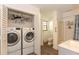 Convenient laundry area with modern washer and dryer units, next to updated bathroom at 781 Little Pine Dr, South Daytona, FL 32119