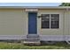 Charming home exterior with a blue door, small awning, and well-maintained landscaping at 1610 Reynolds Rd # 5, Lakeland, FL 33801