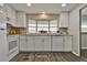 Bright kitchen features white cabinetry, granite countertops, and a large window over the sink at 1610 Reynolds Rd # 5, Lakeland, FL 33801