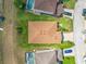 An aerial view of a single-Gathering home highlighting its manicured lawn, roof, driveway, and proximity to other homes and a pool at 358 Canna Dr, Davenport, FL 33897