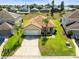 Aerial view of home with well-manicured lawn, landscaping, and concrete driveway in a residential neighborhood at 358 Canna Dr, Davenport, FL 33897