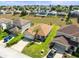 Home aerial with well-kept lawn, landscaping, long driveway, and neighborhood at 358 Canna Dr, Davenport, FL 33897