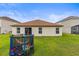 Back of home shows a well-maintained yard with a trampoline, sliding door access, and backyard lawn at 358 Canna Dr, Davenport, FL 33897