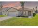 Charming single-story home featuring a two-car garage, manicured lawn, and tasteful landscaping at 358 Canna Dr, Davenport, FL 33897