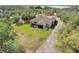 Aerial view of home with screened in porch, lush green lawn, mature trees and long driveway at 3979 Mammoth Grove Rd, Lake Wales, FL 33898