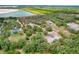 Aerial view shows the property's border, lush greenery, a well-maintained house, and proximity to a lake at 3979 Mammoth Grove Rd, Lake Wales, FL 33898