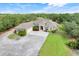 Aerial view of a single-story home featuring a two-car garage, archway entrance, mature landscaping, and a large gravel driveway at 3979 Mammoth Grove Rd, Lake Wales, FL 33898