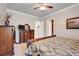 Cozy bedroom featuring a wooden dresser, ceiling fan, and view through the door to the bathroom at 3979 Mammoth Grove Rd, Lake Wales, FL 33898
