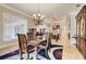 Well-lit dining room with modern chandelier, wooden furniture and view to the kitchen at 3979 Mammoth Grove Rd, Lake Wales, FL 33898