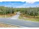 Gated driveway with a wooden fence leading to the secluded property, surrounded by lush trees and landscaping at 3979 Mammoth Grove Rd, Lake Wales, FL 33898