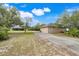 Lovely exterior view of property showcasing driveway, lawn, and home with a bright blue sky at 3979 Mammoth Grove Rd, Lake Wales, FL 33898