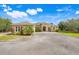 Charming single-story home featuring a well-manicured lawn, mature landscaping, and a circular driveway at 3979 Mammoth Grove Rd, Lake Wales, FL 33898