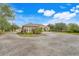 Stunning single-story home with a two-car garage, mature landscaping, archway entrance and gravel driveway on an expansive lot at 3979 Mammoth Grove Rd, Lake Wales, FL 33898