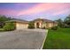 Beautiful single-story home features a two-car garage, archway entrance, and manicured landscaping with vibrant flowers and palm trees at 3979 Mammoth Grove Rd, Lake Wales, FL 33898
