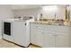 Functional laundry room with granite countertop, stainless sink, and modern washer and dryer at 3979 Mammoth Grove Rd, Lake Wales, FL 33898