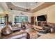 Spacious living room featuring leather furniture, a ceiling fan, and sliding glass doors to a lanai at 3979 Mammoth Grove Rd, Lake Wales, FL 33898