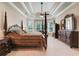 Spacious bedroom with a four-poster bed, tray ceiling, and large windows at 3979 Mammoth Grove Rd, Lake Wales, FL 33898