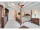 Luxurious bedroom featuring a four-poster bed, tray ceiling, and elegant furniture at 3979 Mammoth Grove Rd, Lake Wales, FL 33898