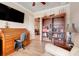 Office area with wooden rolltop desk, bookshelf, and view to the living room at 3979 Mammoth Grove Rd, Lake Wales, FL 33898