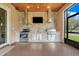 Outdoor kitchen featuring stainless steel appliances, stone accents, a built-in grill, and a TV at 3979 Mammoth Grove Rd, Lake Wales, FL 33898
