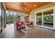 Relaxing outdoor patio with comfortable seating and ceiling fans overlooking the lush backyard at 3979 Mammoth Grove Rd, Lake Wales, FL 33898
