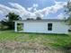 The backyard showcases a well-maintained lawn and a glimpse of the covered patio at 481 S East Ave, Bartow, FL 33830