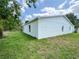 The backyard features a pristine exterior with bright windows and lush green grass at 481 S East Ave, Bartow, FL 33830