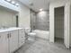 Modern bathroom with gray tile surround, vanity, commode and doorway into linen closet at 481 S East Ave, Bartow, FL 33830