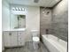 Modern bathroom featuring a bathtub with shower, gray tile surround, and white vanity sink at 481 S East Ave, Bartow, FL 33830