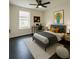 Nicely staged bedroom with dark wood floors, gray bed, modern decor, and natural light at 481 S East Ave, Bartow, FL 33830