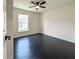 Bedroom features dark wood floors, a ceiling fan, and a bright window at 481 S East Ave, Bartow, FL 33830