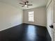 Bedroom features dark wood floors, a ceiling fan, and a window providing natural light at 481 S East Ave, Bartow, FL 33830