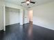 A spacious bedroom featuring dark wood floors, a ceiling fan and a large closet at 481 S East Ave, Bartow, FL 33830