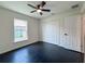A well-lit bedroom featuring dark wood floors, a ceiling fan, and a closet at 481 S East Ave, Bartow, FL 33830