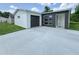 Modern home featuring a gray and white exterior, sleek windows, and a spacious driveway at 481 S East Ave, Bartow, FL 33830