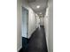 Clean hallway with white walls and doors and dark hardwood flooring leading to rooms at 481 S East Ave, Bartow, FL 33830