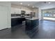 Bright kitchen featuring a central island, stainless steel appliances, and modern white and black cabinets at 481 S East Ave, Bartow, FL 33830