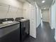 The well-lit laundry room with a modern Samsung washer and dryer and wire shelf for storage at 481 S East Ave, Bartow, FL 33830