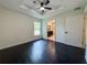 Main bedroom features dark floors, ceiling fan, tray ceiling, bright window, and ensuite bathroom at 481 S East Ave, Bartow, FL 33830