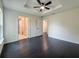 Main bedroom featuring dark floors, tray ceiling, ceiling fan, ensuite bathroom, and closet at 481 S East Ave, Bartow, FL 33830